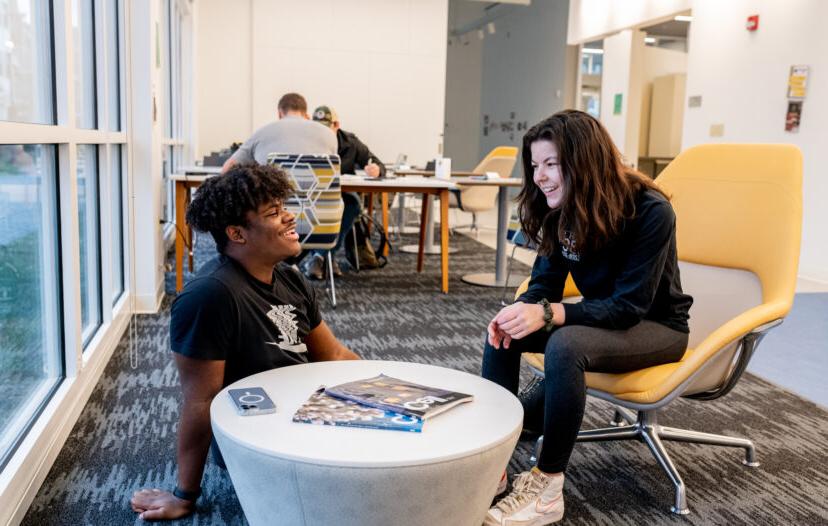 Two trinity college students conversing in a study lounge